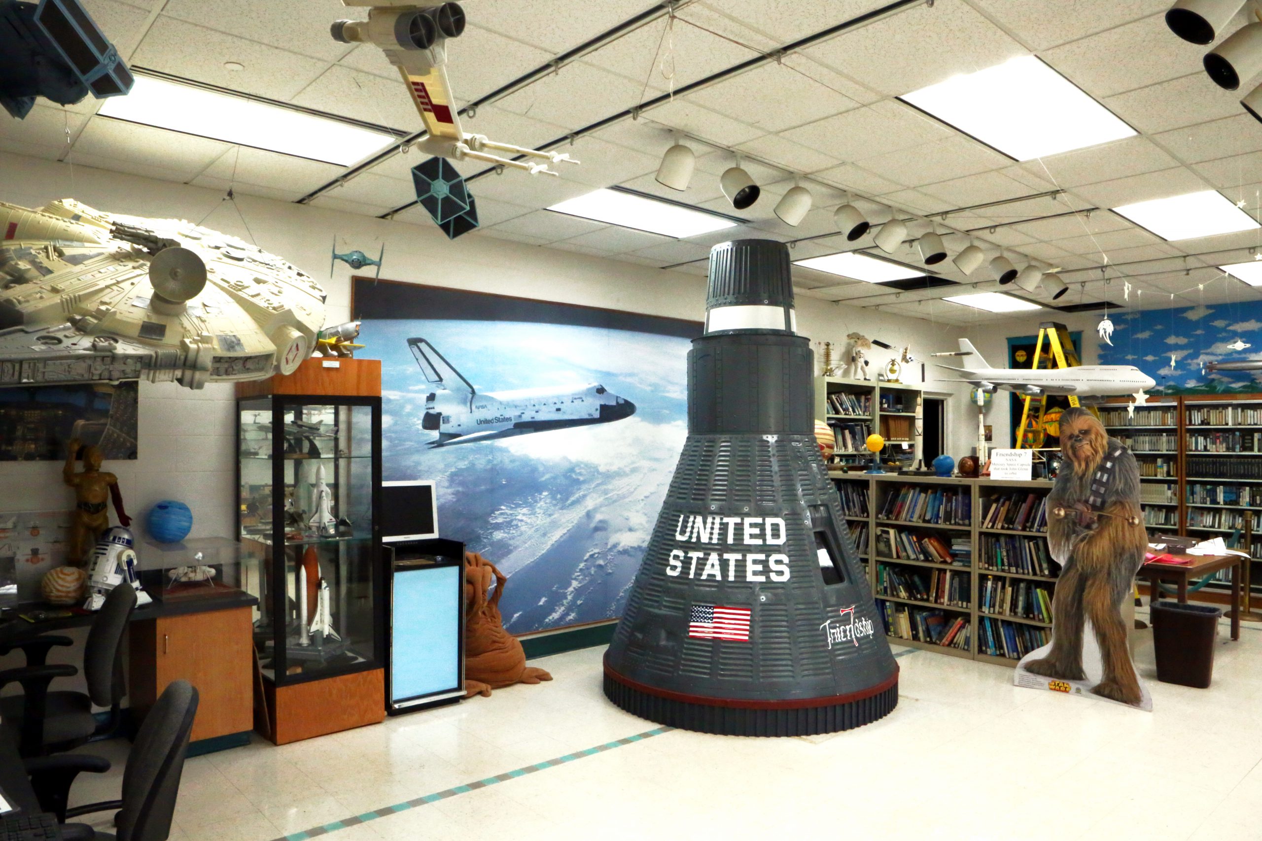 Exploration lab with large model of Millennium Falcon, a space shuttle capsule, Chewbacca cardboard cutout, books, and other fun toys