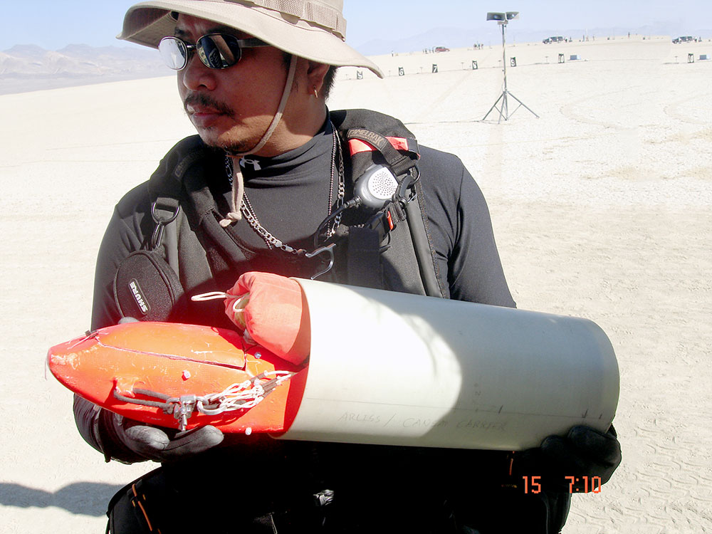 ARLISS team member holding a packaged rocket parachute