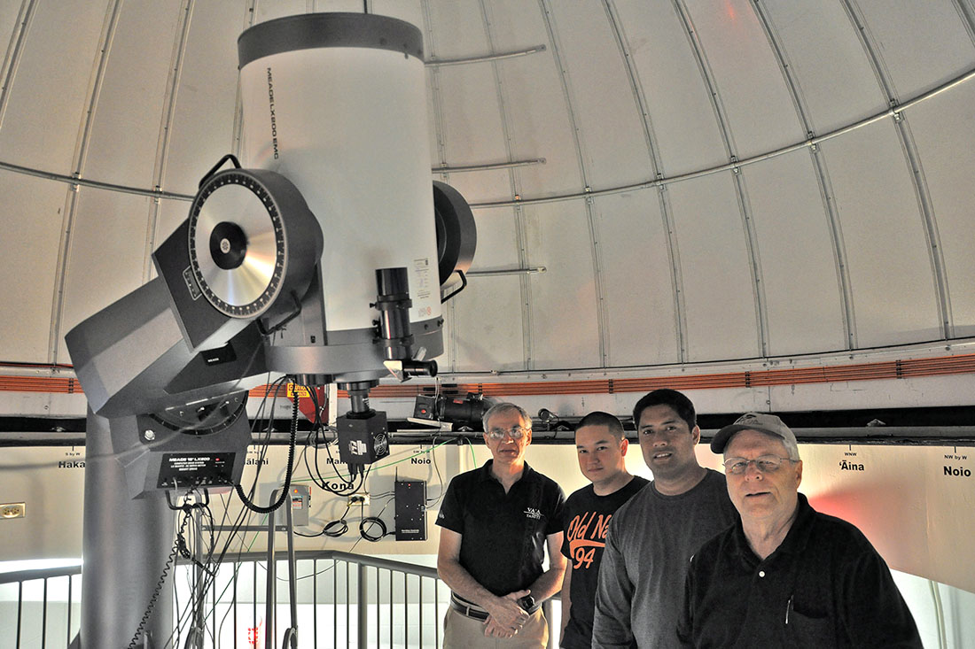 students standing inside the observatory next to the large telescope