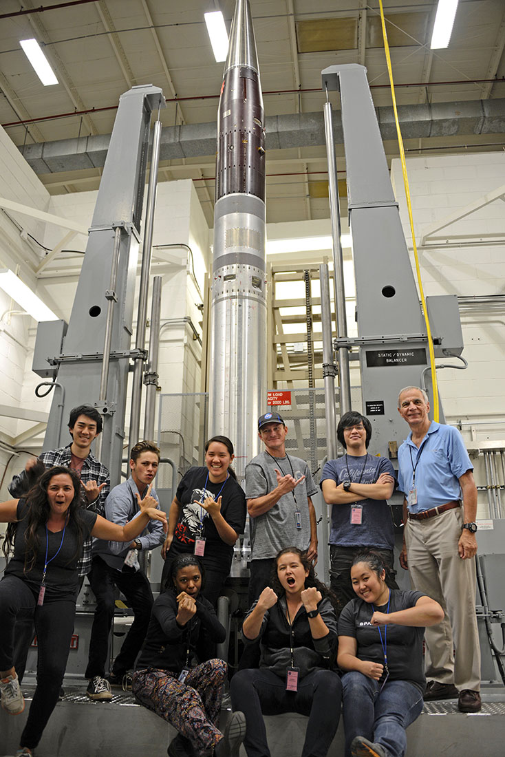 group of students standing in front of a 20 foot tall rocket