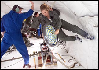 student in the zero gravity plane holding a spinning wheel