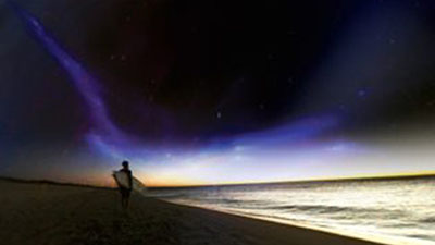 man on beach at night against the night sky