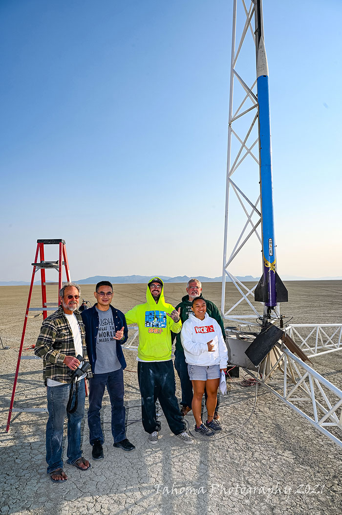 mission 9 team members standing next to their rocket